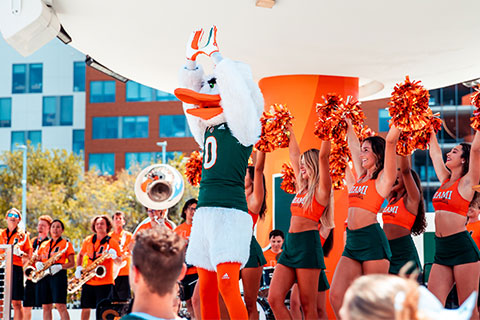 Sebastian the Ibis throws up the U at a pep rally.